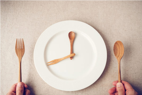 Assiette blanche avec couverts en forme d'horloge